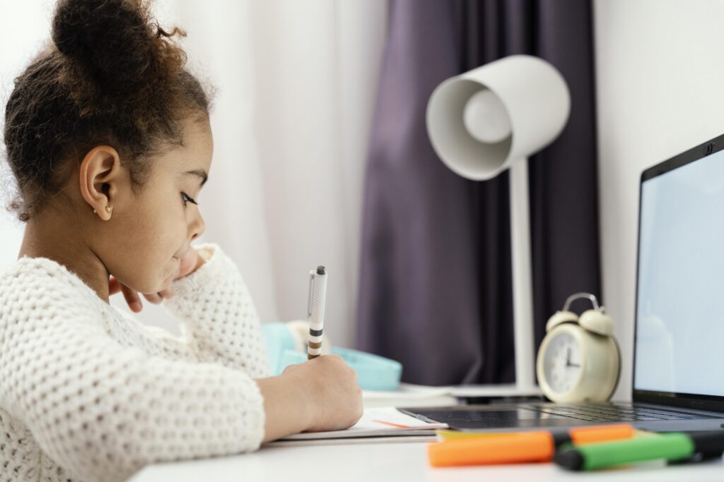 side-view-little-girl-attending-online-school-home-using-laptop